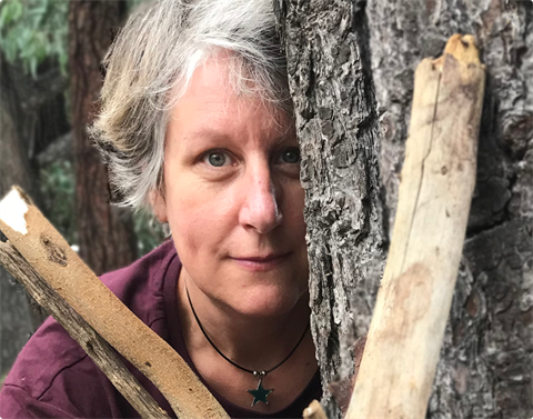 Portrait of a woman looking through tree branches