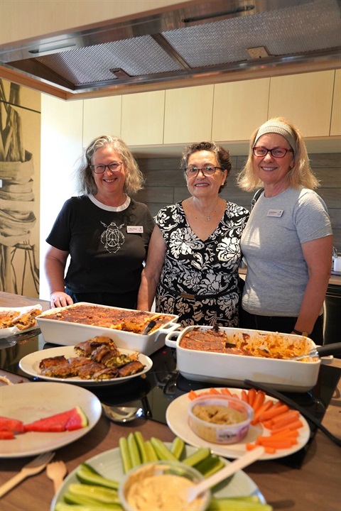 3 women in a kitchen with food