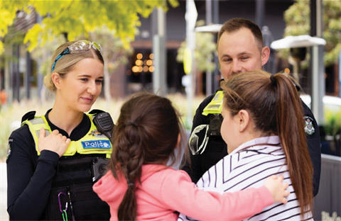 Police officers smiling and talking with mother and child