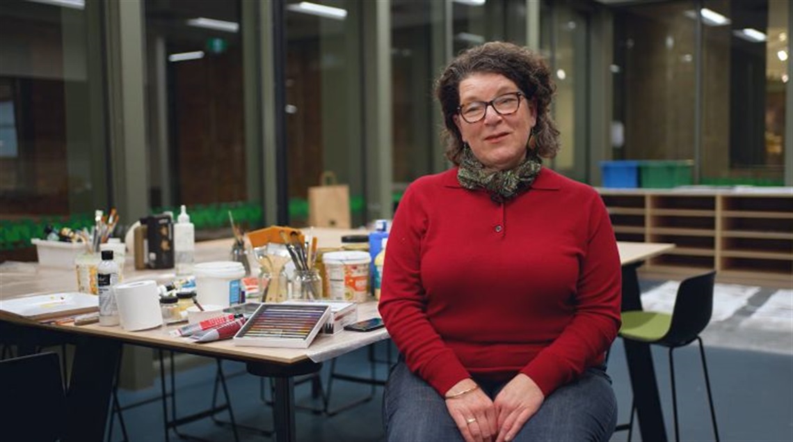Woman with disabiukity by a table with stuff on it