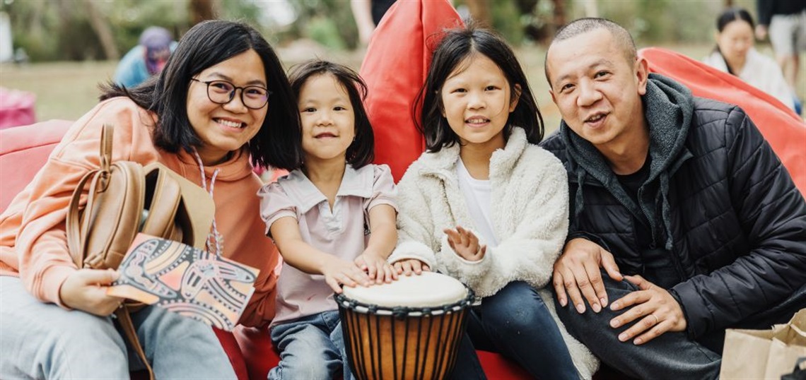 Parents and choldren with drum at outdoor festival