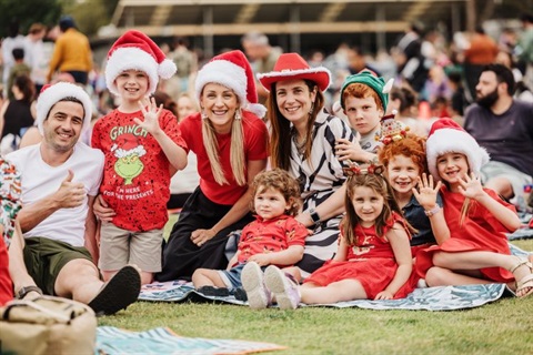 Festive people sitting on lawn at Christmas